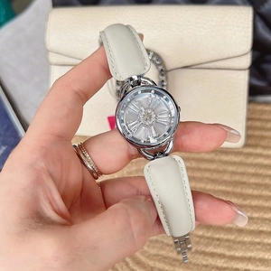 Close-up of elegant women watch with white leather strap and crystal rotating flower dial