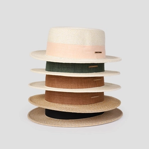 Détail de chapeaux de paille avec rubans colorés et plaques logo en métal