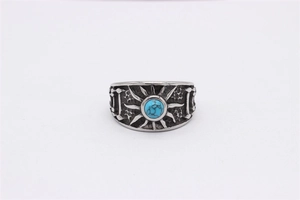 Détail macro d'une bague rétro en acier avec turquoise bleue et texture soleil