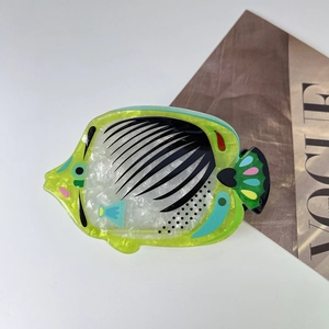 Vue détaillée d'une pince à cheveux en forme de poisson tropical en acétate vert citron