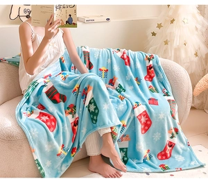 Detail of soft blue flannel Christmas blanket with holiday socks and snowflake prints