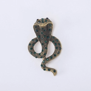 Macro detail of cobra brooch showing gold plating and dense green rhinestone inlay