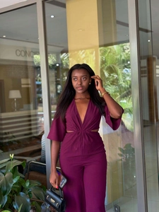 Detail of deep V-neck jumpsuit with hollow-out waist knot and elegant flared sleeves