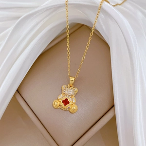 Close-up of golden bear pendant with sparkling crystals and a red heart gemstone