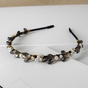 Close-up of handmade crystal headband with grey stones, pearls and golden beads detail
