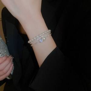 Detail of layered silver bracelet with pearls and sparkling crystals on model wrist