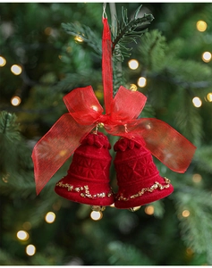 Detail of red flocked Christmas bells with a sheer organza bow on a festive background