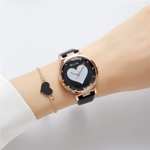 Close-up of a rose gold heart watch with black leather strap and matching bracelet