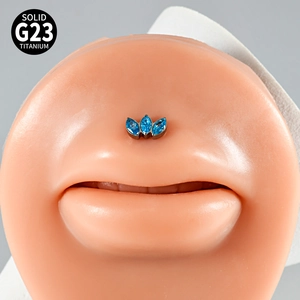 Macro shot of G23 titanium labret stud with three blue marquise zircons on a model