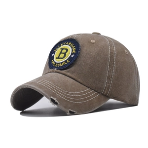 Detail of vintage washed cotton baseball cap with embroidered B patch and distressed brim