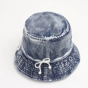 Detail of washed denim bucket hat featuring white pearl bows and vintage texture