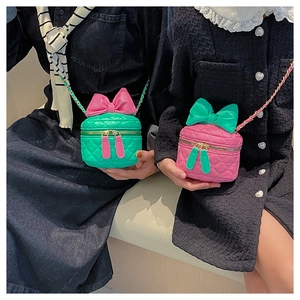 Close-up of quilted cross-body bags for girls with bows and gold chain straps