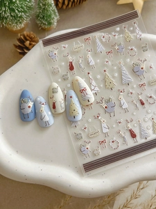 Detailed view of 5D embossed Christmas nail stickers featuring reindeer and tree patterns