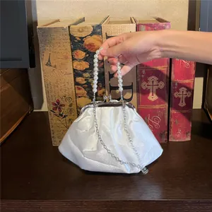 Detail of white satin evening bag with pearl handle and vintage silver kiss lock clasp