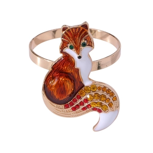 Enameled metal fox napkin ring with colorful rhinestones on a white background