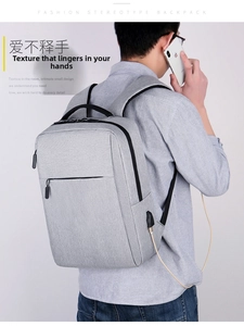 Close-up of side USB charging port on a grey business laptop backpack with cable