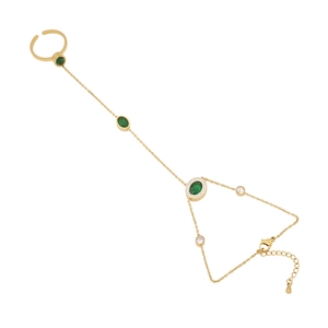 Gold slave bracelet with emerald green stones and white zircons on a white background