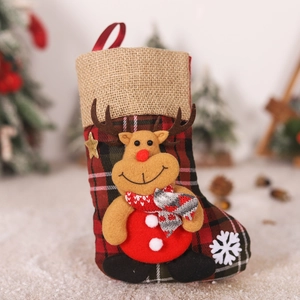 Detail of Christmas stocking with 3D plush reindeer on red and green plaid fabric