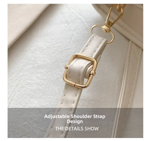 Detail showing the adjustable shoulder strap with gold metal buckle on a beige bag