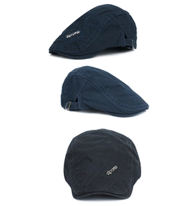 Detail of navy cotton newsboy cap with metal SPORTS emblem and adjustable buckle