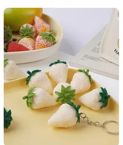 Macro shot of realistic white strawberry resin keychain charms with metal rings