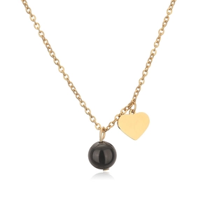 Detail of gold heart pendant and black bead on a stainless steel necklace chain
