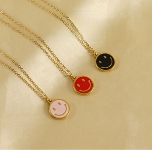 Detailed close-up of colorful enamel smiley face necklaces on gold stainless steel chains