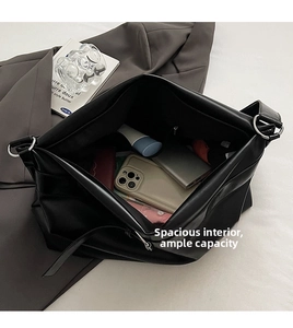 Vue de dessus montrant l'intérieur spacieux du sac cabas en cuir noir avec accessoires