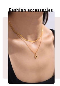 Detailed view of layered gold star pendant necklace with green zircon on model