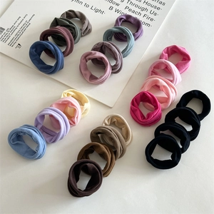 Detailed arrangement of soft seamless fabric hair ties in various neutral and pastel colors
