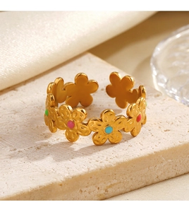 Détail d'une bague fleurie dorée avec émail coloré sur une surface en pierre texturée