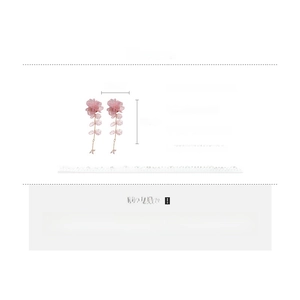 Detail view of pink fabric floral tassel earrings with silver needles and leaf accents