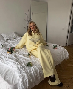 Detail of the pale yellow half-zip sweatshirt with Saint Louis embroidery and soft fabric