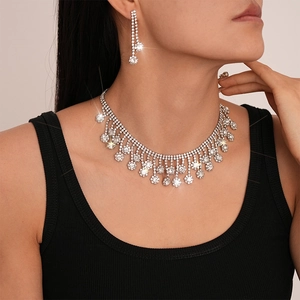 Détail de l'ensemble collier et boucles d'oreilles argentées avec pompons de fleurs