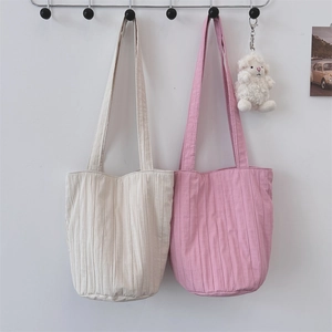 Bolsos tote plisados en beige y rosa colgados en la pared para uso diario común