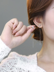 Close-up of a silver floral tassel earring with sparkling diamonds on a model