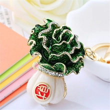 Detail of cabbage keychain with green enamel, white pearls and gold accents