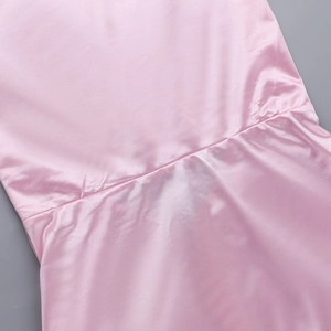 Détail de la couture et de la texture du tissu satiné rose de cette robe élégante