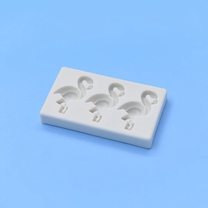Detail view of white silicone mold featuring three standing flamingo cavity patterns