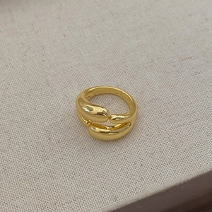 Detailed view of a gold double-layer minimalist ring on a soft linen fabric background