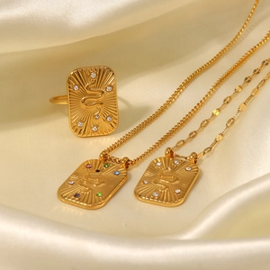 Gold snake jewelry set with colorful gemstones including ring and necklaces on silk
