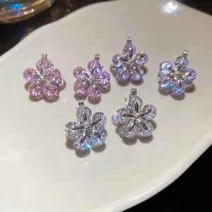 Elegant zircon flower earrings in pink, purple and silver on a white ceramic tray