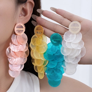 Detail of colorful tiered drop earrings with multi-layer round shell-like discs