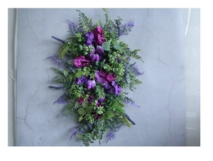 Close-up of purple lavender and pink blooms with green leaves on a floral wreath