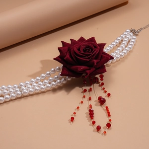 Détail de la rose en tissu bordeaux et tour de cou perles à trois rangs avec glands
