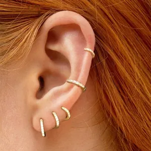 Dettaglio di orecchini a cerchio dorati con zirconi in misure da 6mm a 9mm