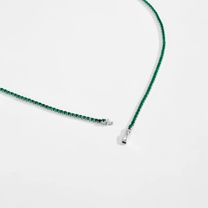 Detail view of the silver tennis chain necklace with green zircon and secure clasp