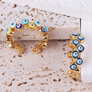 Detail of adjustable gold-plated open rings with colorful evil eye enamel beads