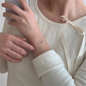 Close-up of a 925 sterling silver bow bracelet worn on a wrist for an elegant look