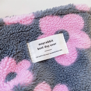 Close-up of gray plush canvas bag with pink floral pattern and mayrabbit woven label